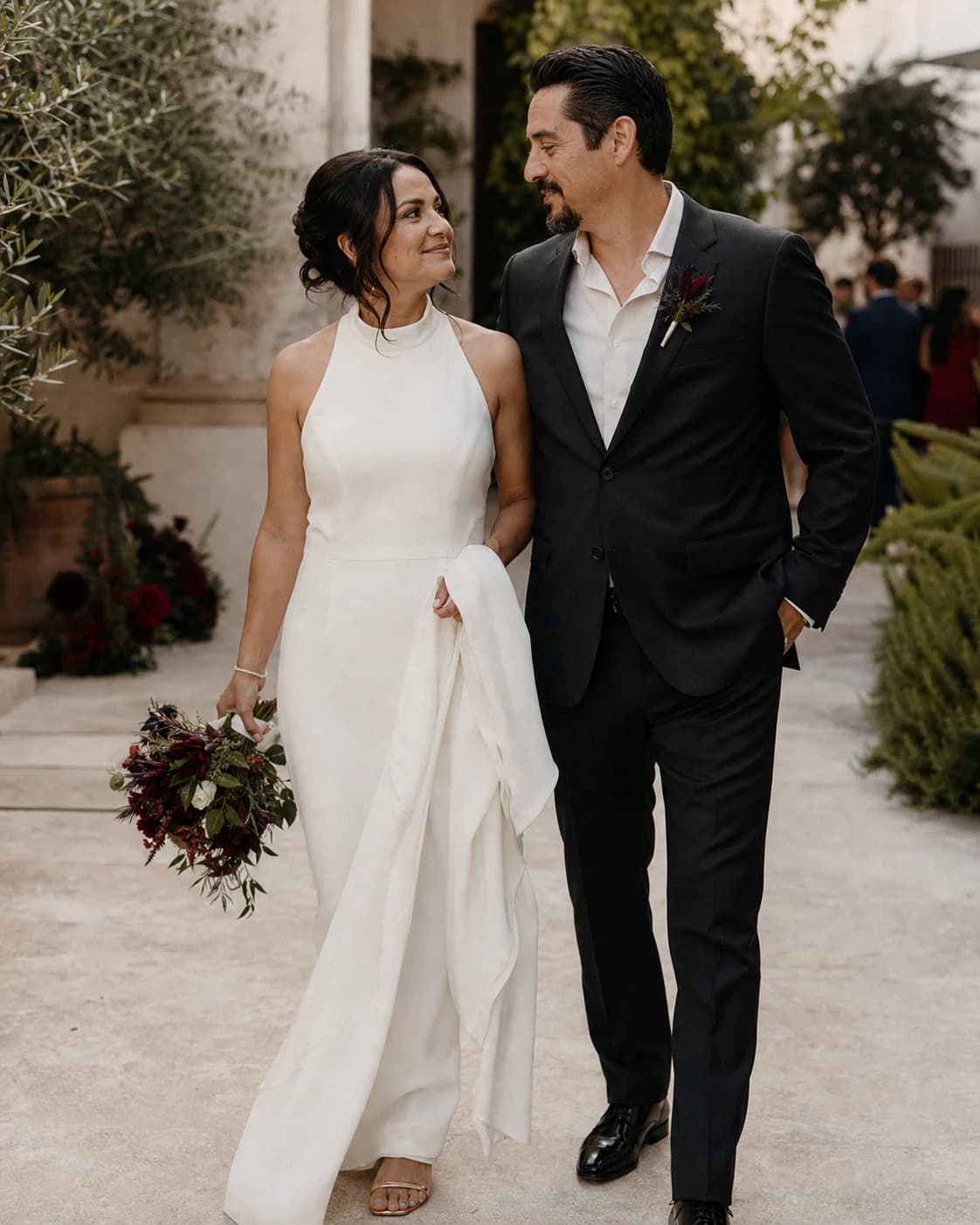 A newly married couple walking together after an intimate garden ceremony